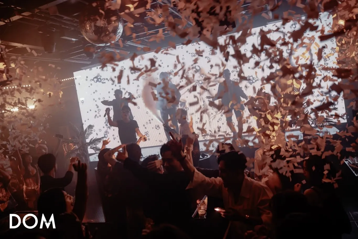Confetti falling over performers and a dancing crowd inside DOM Nha Trang